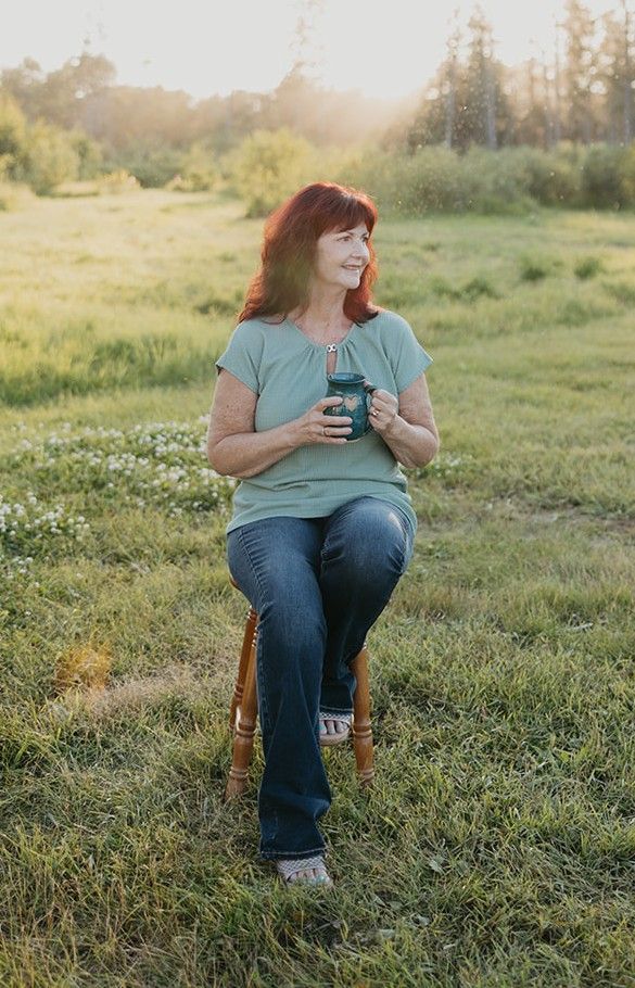 woman sitting on a stool in a field